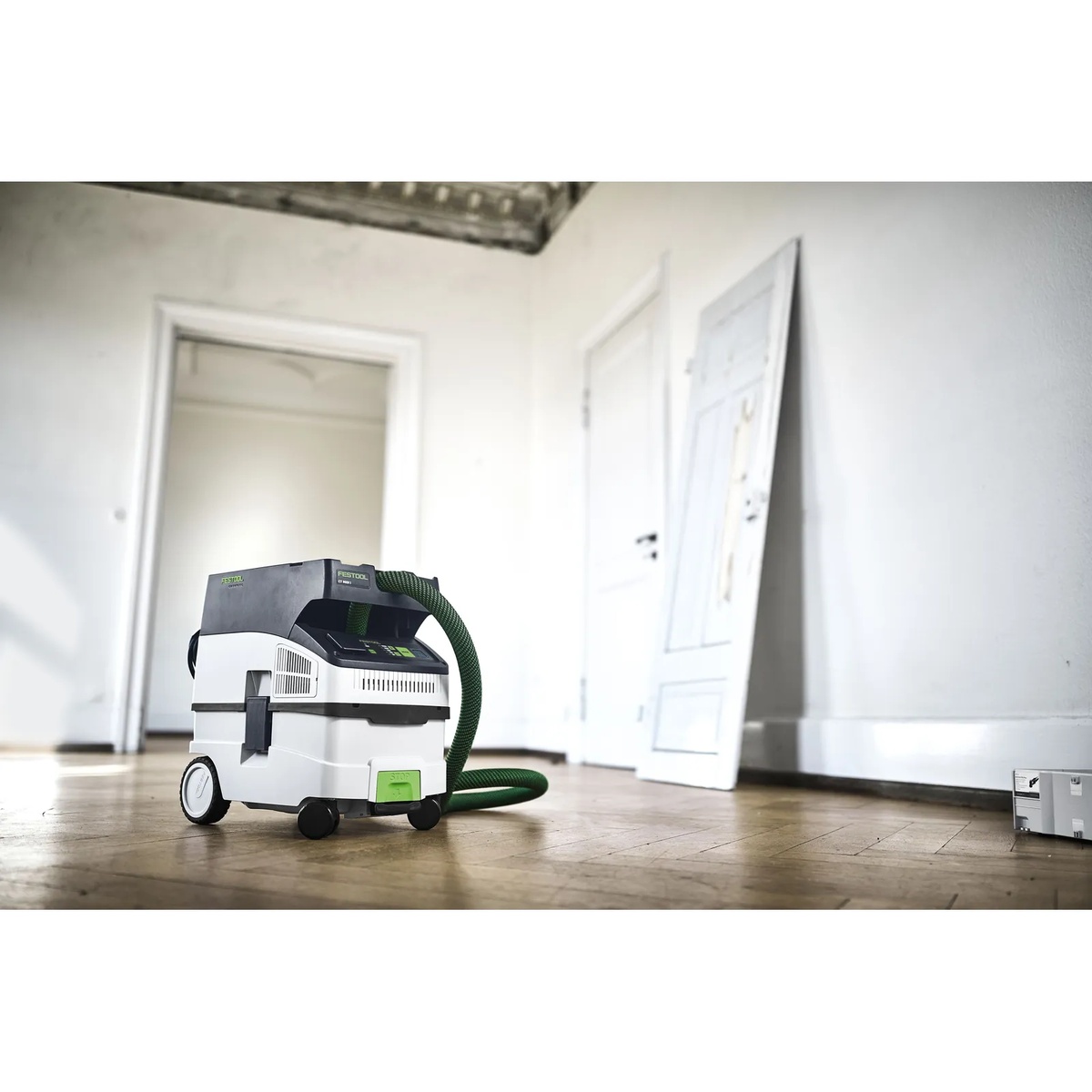 Festool CT MIDI I HEPA dust extractor staged in a room renovation space with hose stored neatly for mobile transport and cleanup