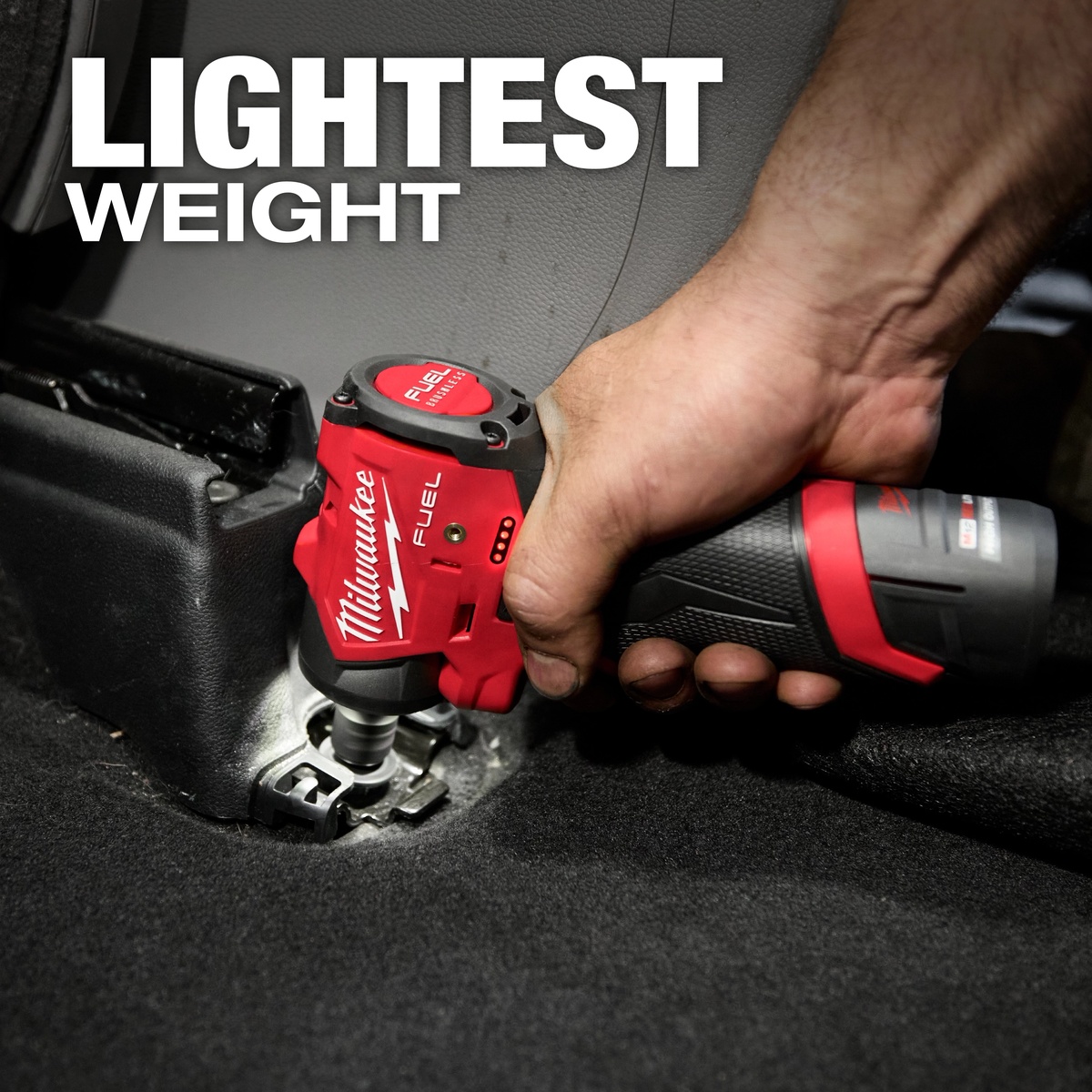 Milwaukee 3048-20 M12 FUEL 1/4 inch subcompact impact wrench used one-handed in a tight automotive interior fastening application