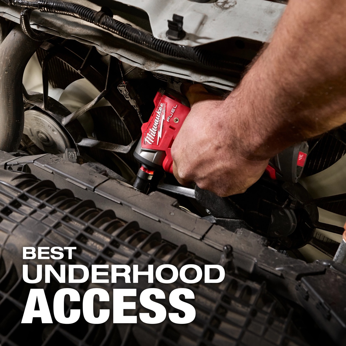 Milwaukee 3048-20 M12 FUEL 1/4 inch subcompact impact wrench removing a fastener under a vehicle hood in a tight engine bay service area