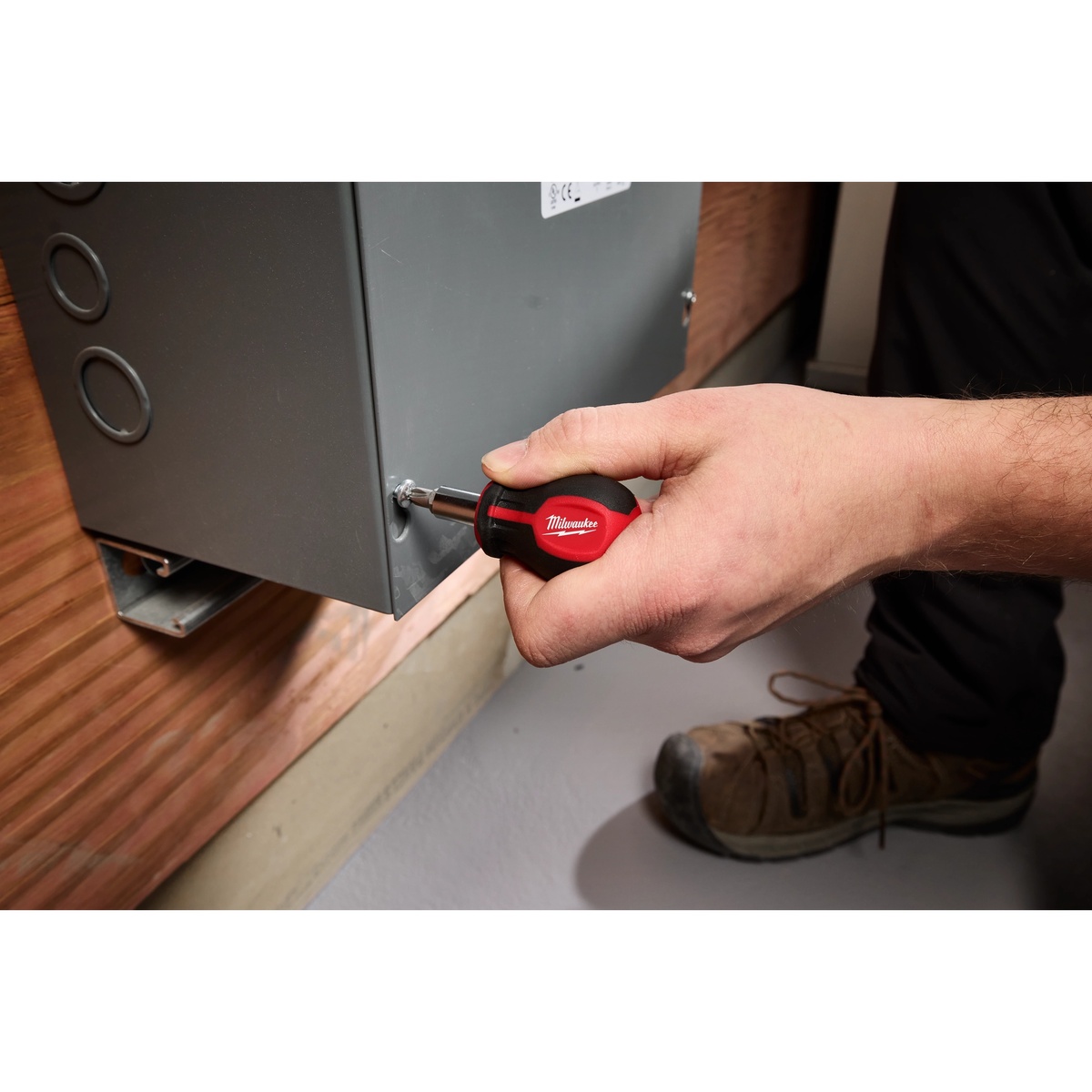 Milwaukee 48-22-2762 6-IN-1 Stubby Multi-Bit Screwdriver driving a screw into metal equipment housing during installation work