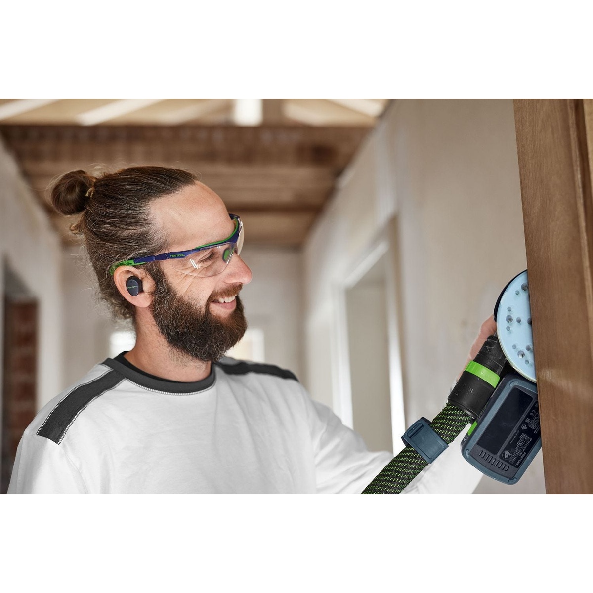 Festool Cordless 18V ETSC 2 150mm (6-in.) Sander being used vertically on a wood surface with dust extraction connected during finish sanding