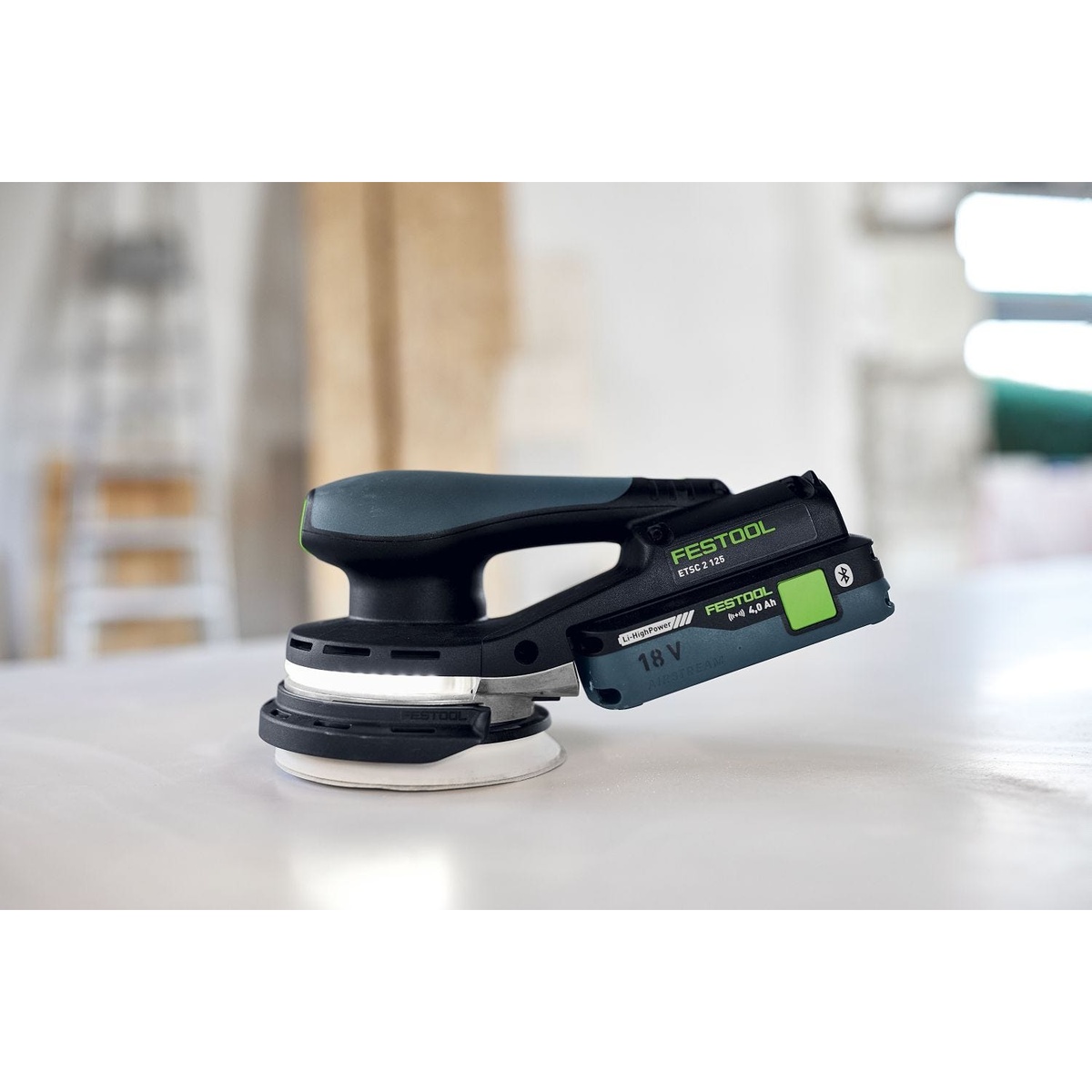 Festool Cordless 18V ETSC 2 125mm (5-in.) sander resting on a finished surface in a workshop setting