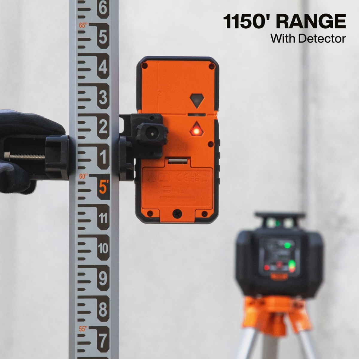 Klein Tools 93RLS Green Rotary Laser Level in use with detector mounted on a grade rod for long-range leveling on a jobsite wall layout