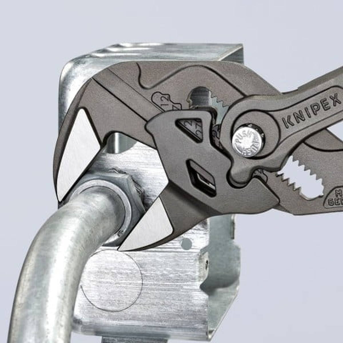 Knipex 9K 00 80 180 US Plumbing 6-Piece Set pliers wrench adjusting a metal fitting on conduit and hardware in close-up shop context