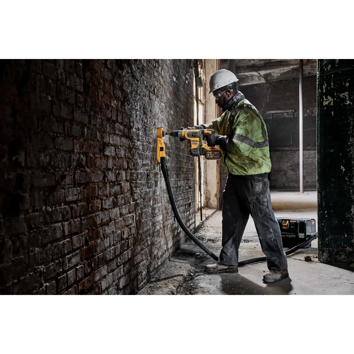 DEWALT DCH416B 60V MAX 1-1/4-in. Brushless Cordless SDS PLUS Rotary Hammer drilling into a brick wall on an indoor renovation jobsite with dust extraction attached