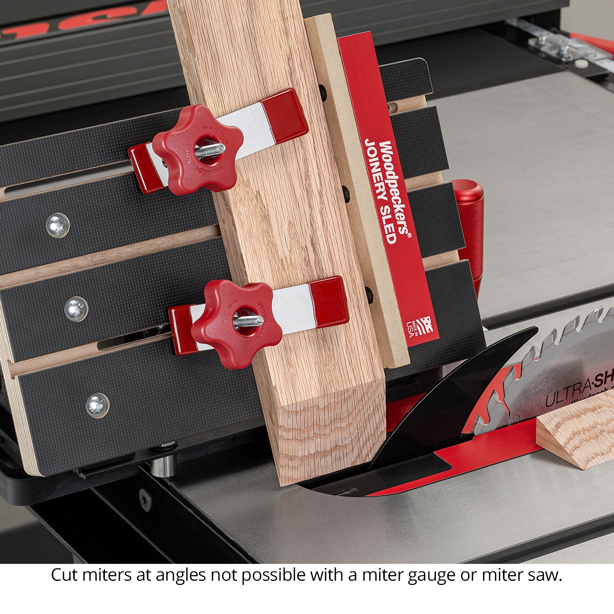 Woodpeckers Joinery Sled holding an angled wood workpiece during a miter cut on a table saw in a woodworking shop