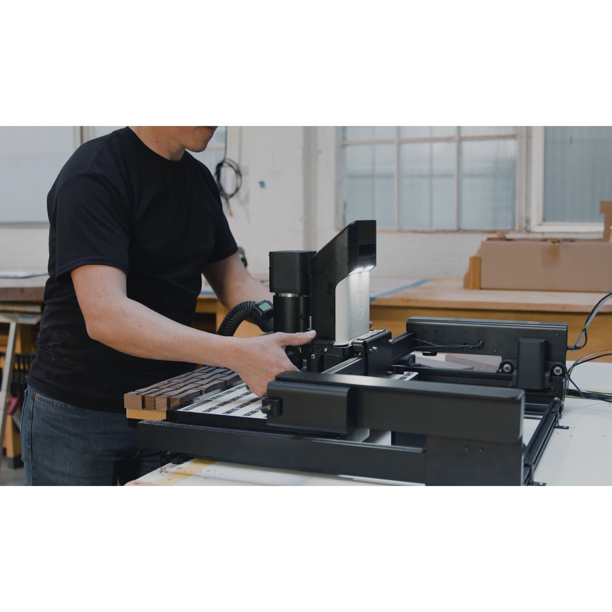 Shaper SCFP1-AJ-NN BenchPilot Hands-Free CNC Bench for Origin with Origin clipped in on a woodworking bench during setup for automated routing in a shop