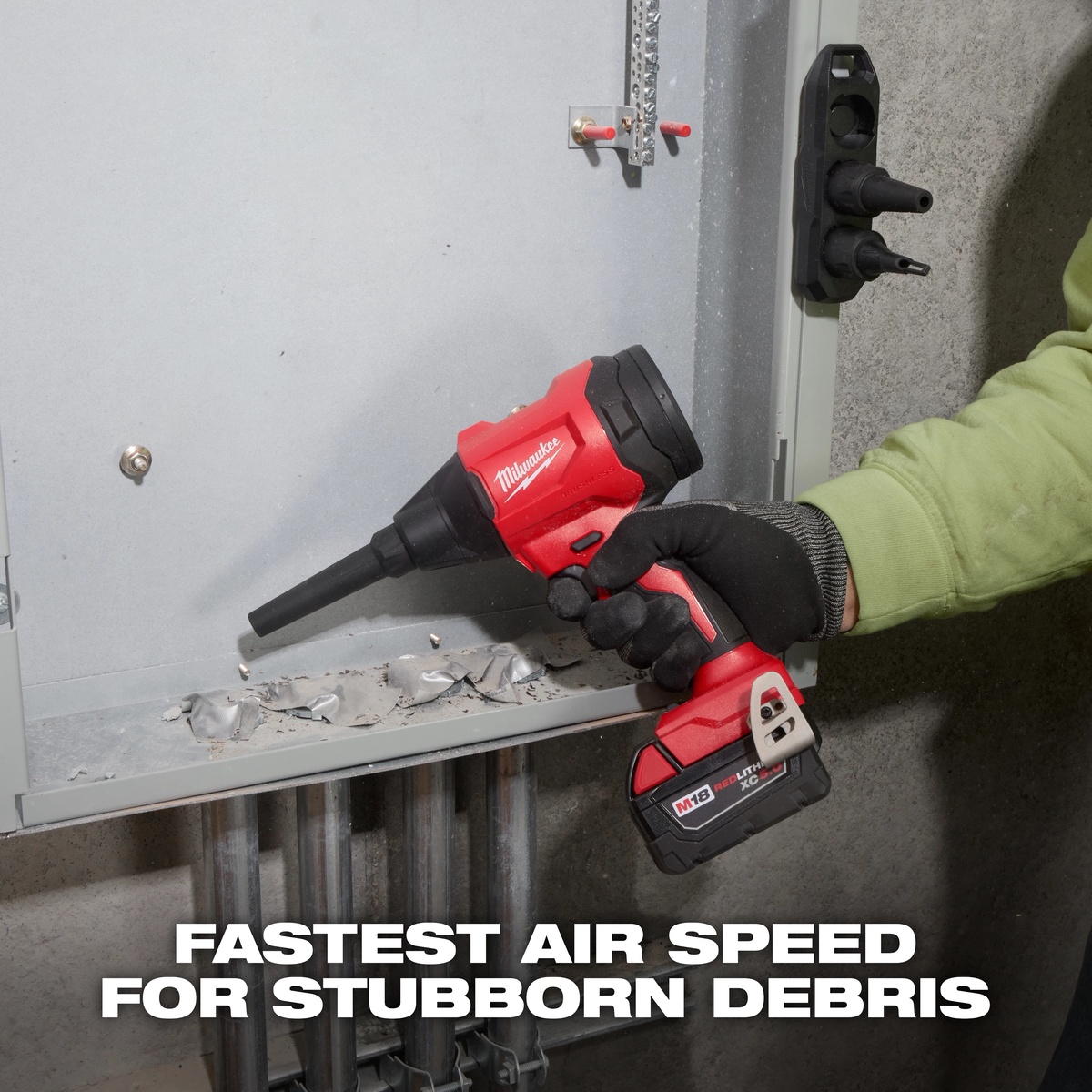 Milwaukee M18 Brushless Precision Blower cleaning debris from an electrical panel in a tight indoor service area with a narrow nozzle attached