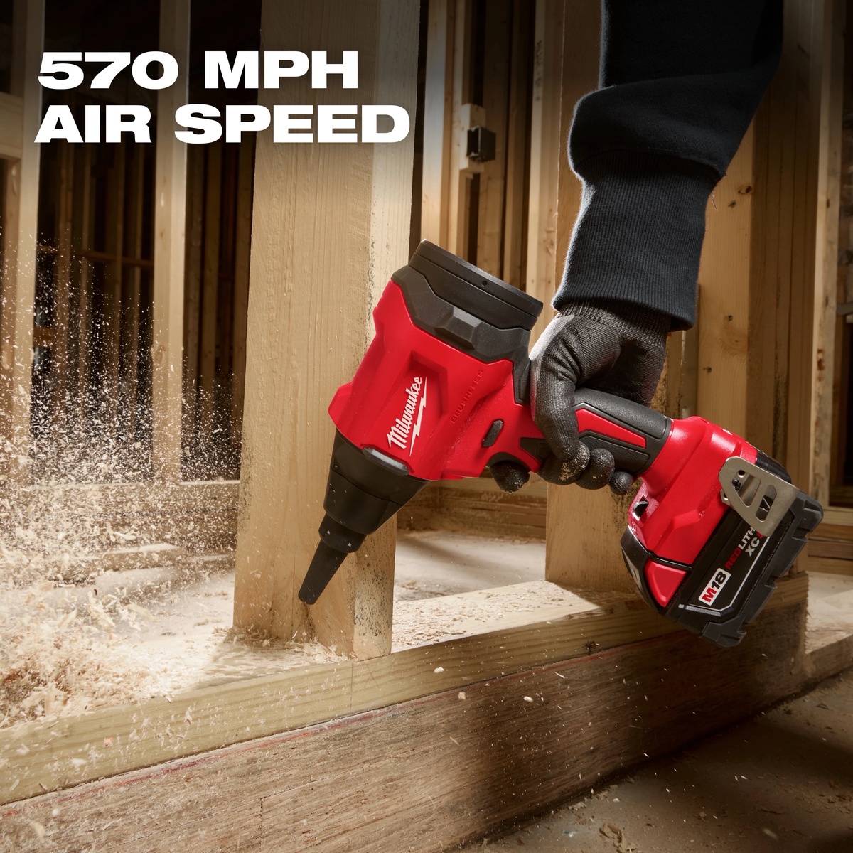 Milwaukee M18 Brushless Precision Blower clearing sawdust from framing lumber on an indoor jobsite with focused high-speed airflow