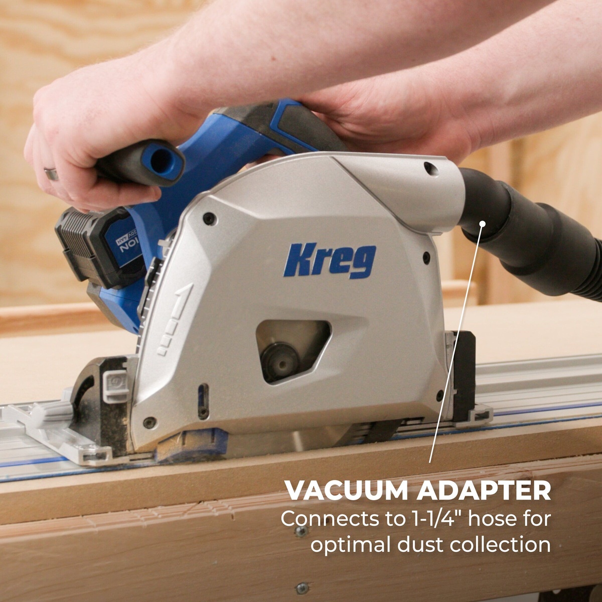 Kreg Tool KPTBPS100A cordless track saw cutting on a guide rail with vacuum hose attached for dust collection during woodworking
