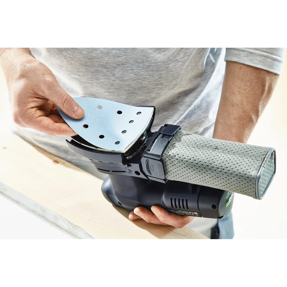Festool Delta P180 GR/100 Granat abrasive sheet being installed on a Festool delta detail sander during wood surface prep in a workshop