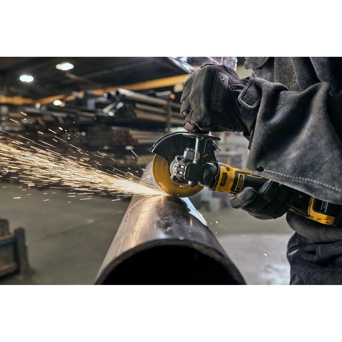 DeWALT DCG402B 20V MAX ATOMIC 4.5-in. Angle Grinder cutting steel pipe in a fabrication shop with sparks during metalworking