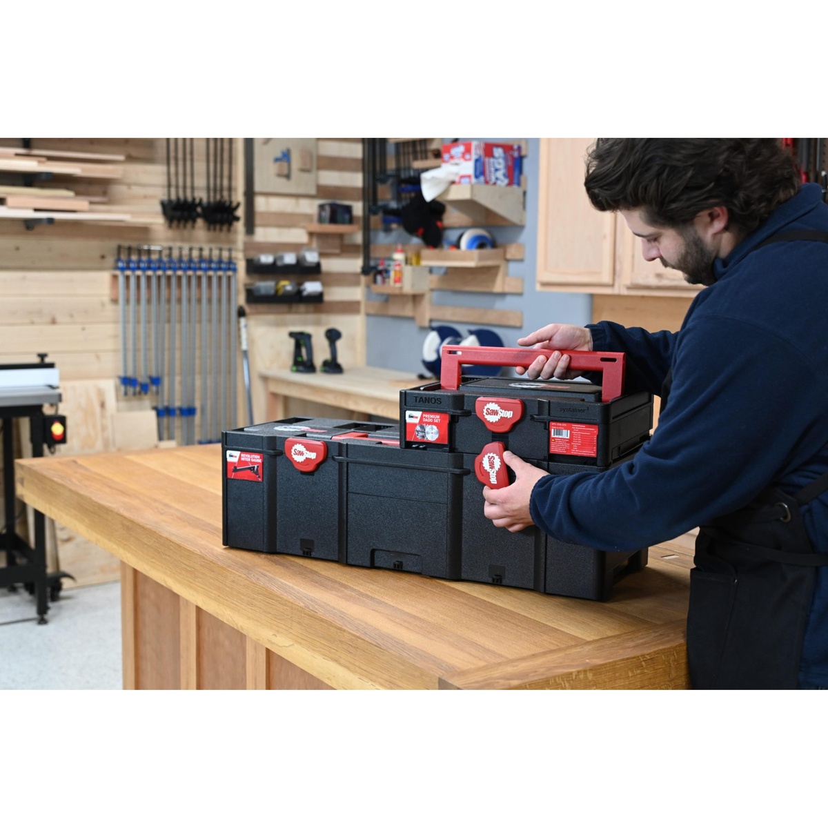 SawStop BTS-DS8-SYS Premium 8-in. Dado Set with Systainer being carried and stacked with another case on a woodworking bench in a workshop