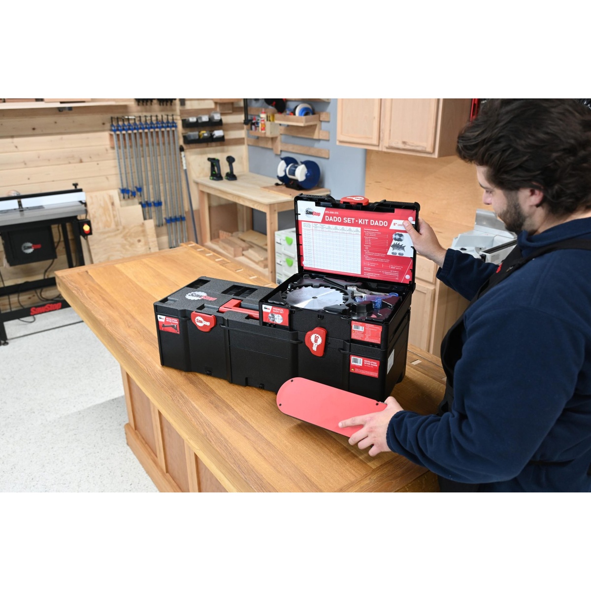 SawStop BTS-DS8-SYS Premium 8-in. Dado Set with Systainer opened on a woodworking bench with the insert plate removed, showing the dado blades and setup chart in a shop environment