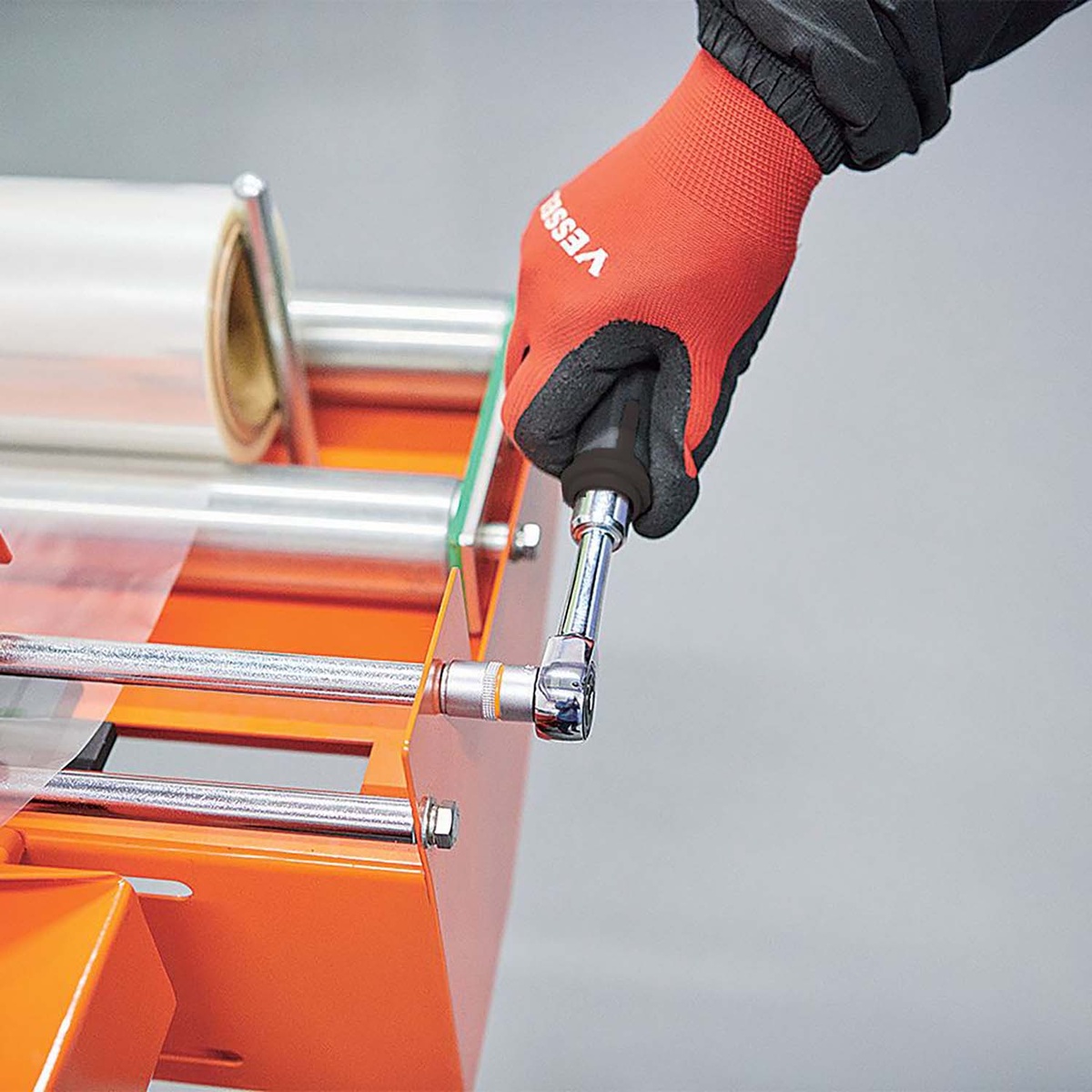 Vessel Tool e-ASSIST MINI Ratchet Wrench 400ER2U tightening hardware on an orange machine frame in a tight metal assembly area