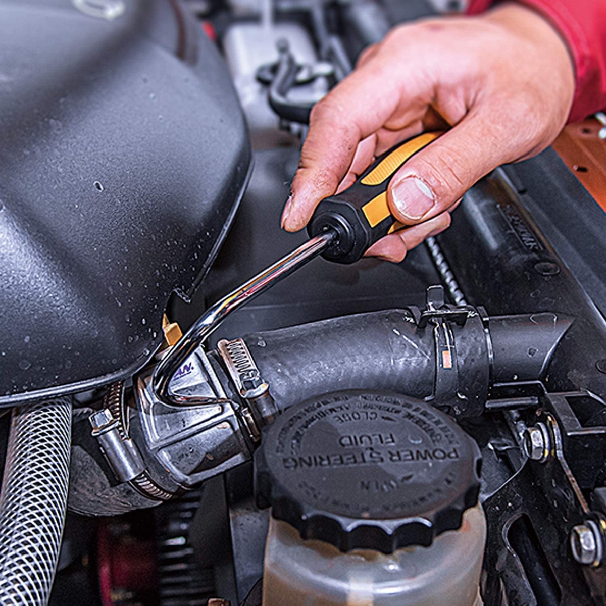 Vessel 970HR3PB MEGADORA Hose Remover 3-Piece Set being used to lift a rubber hose from a fitting inside an automotive engine bay during cooling system service