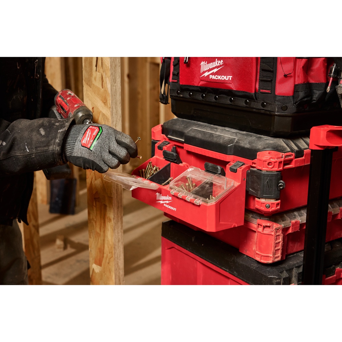 Milwaukee 48-22-8610 PACKOUT Tool Box 2-Bin Attachment mounted on a PACKOUT stack holding screws during framing work on a jobsite