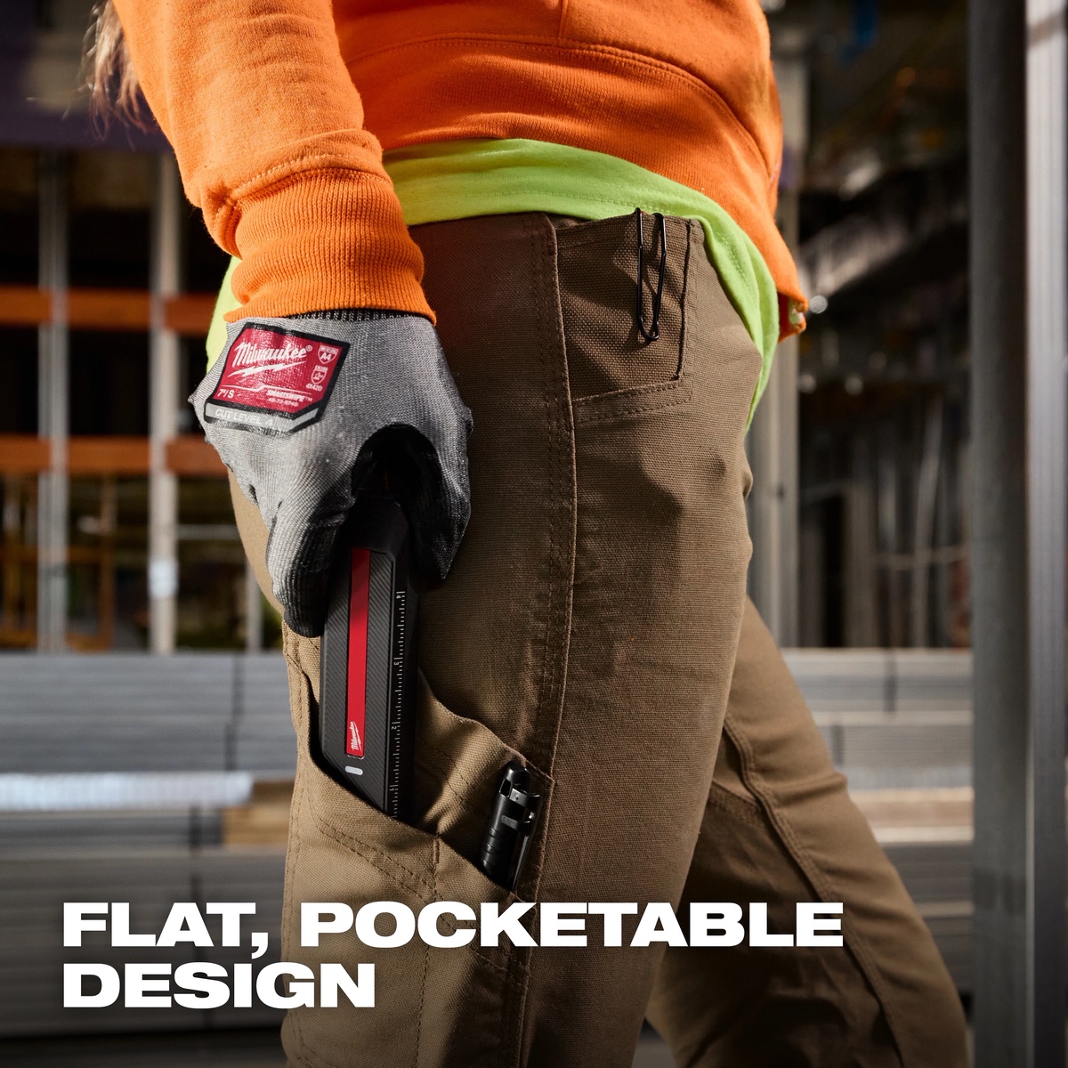 Milwaukee 2016R USB Rechargeable 1300-Lumen Flat Flashlight w/ Green Laser carried in a work pant pocket on a construction jobsite for everyday inspection access