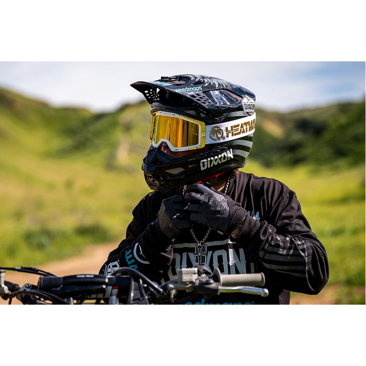 Heat Wave Visual MXG-250 Moto Goggle - Colby Raha 2.0 worn with a motocross helmet during outdoor off-road riding in bright daylight
