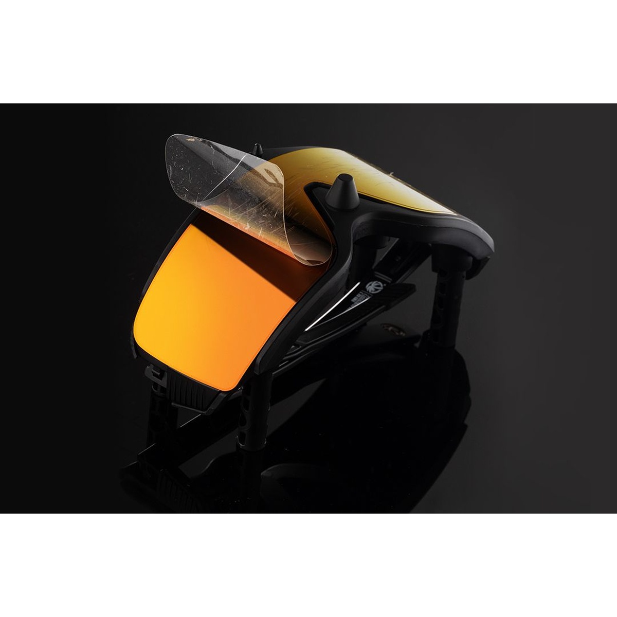 Heat Wave Visual LPF Jig: SKYNET supporting SKYNET sunglasses while protective lens film is lifted during maintenance on a dark work surface