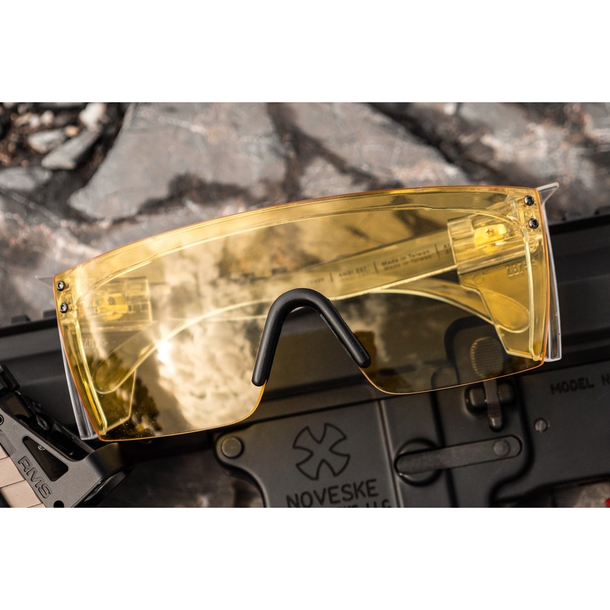 Heat Wave Visual Lazer Face Glasses: HI-VIS YELLOW Z87 with single shield lens and clear frame set on gear in an outdoor equipment setting
