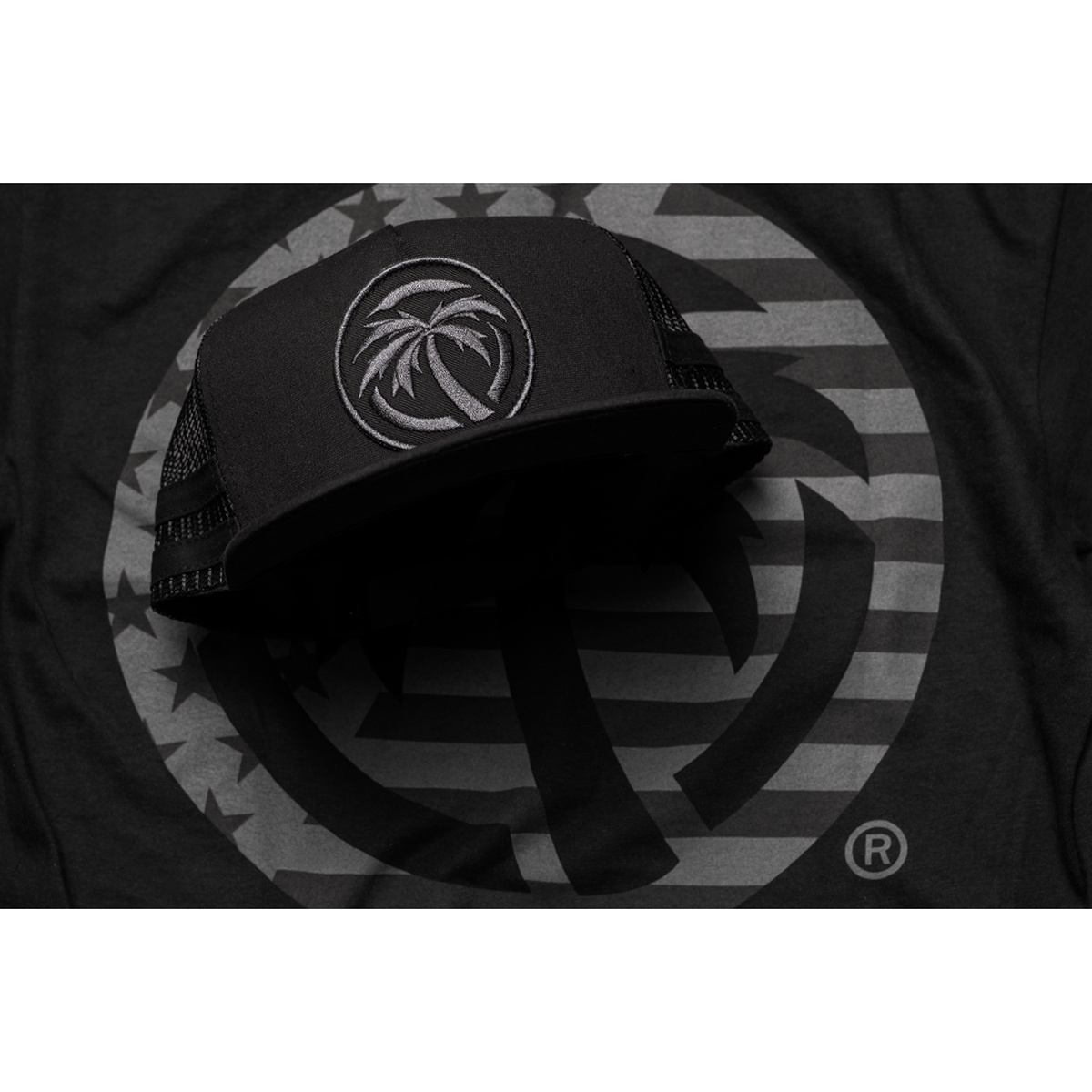 Heat Wave Visual HWV Socom Trucker Hat displayed as black everyday headwear with subdued embroidered palm logo for casual streetwear use