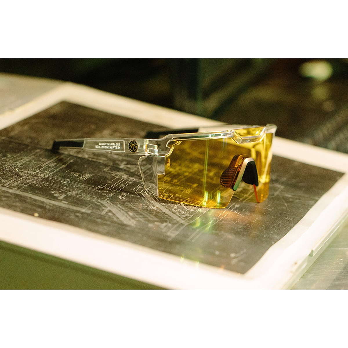 Heat Wave Visual Future Tech Sunglasses Vapor Clear Frame Hi-Vis Yellow Lens Z87+ resting on job plans in a workshop setting for everyday trade and shop use