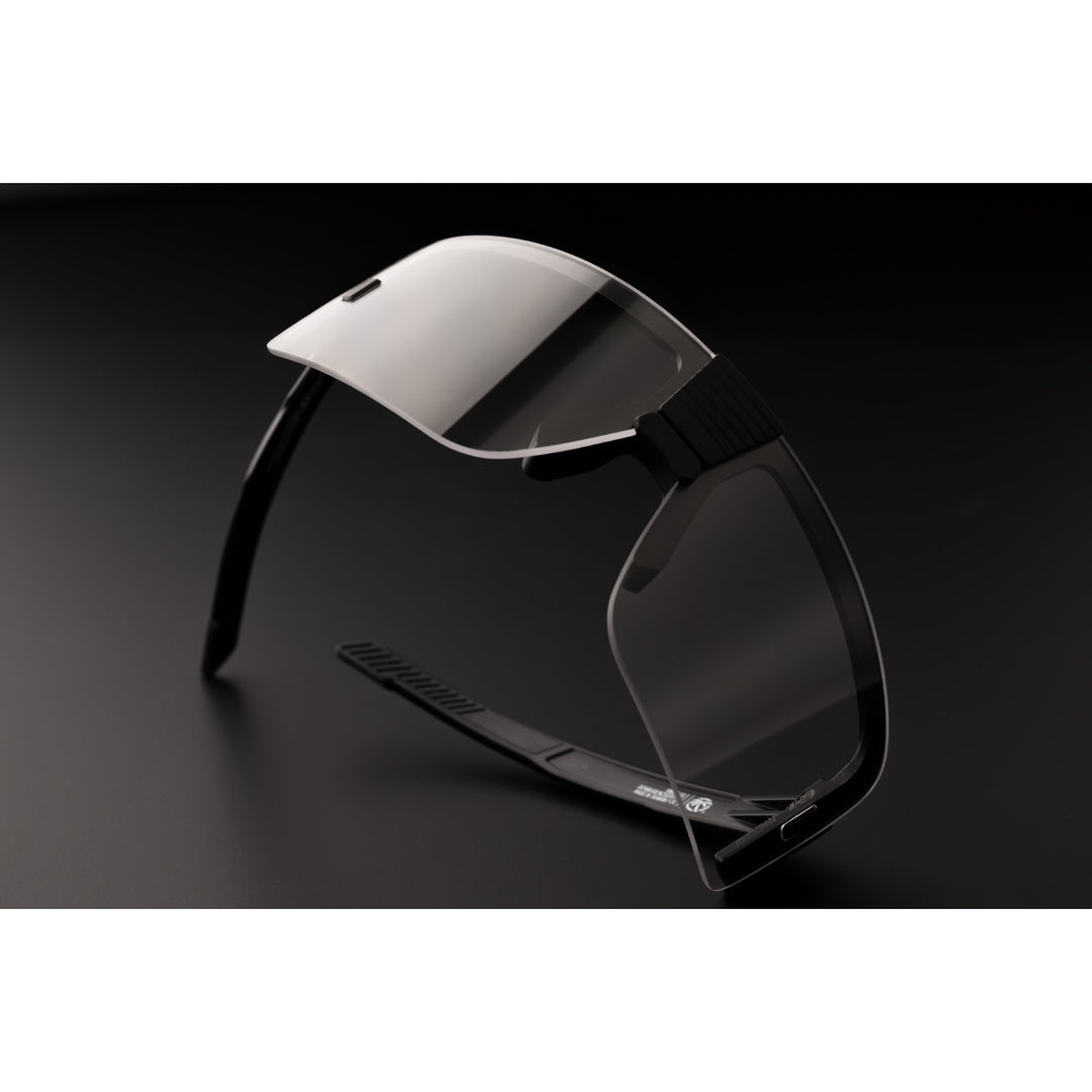 XL Vector clear lens safety sunglasses on a dark workbench surface showing wide one-piece lens for indoor work, garage tasks, and low-light jobsite use