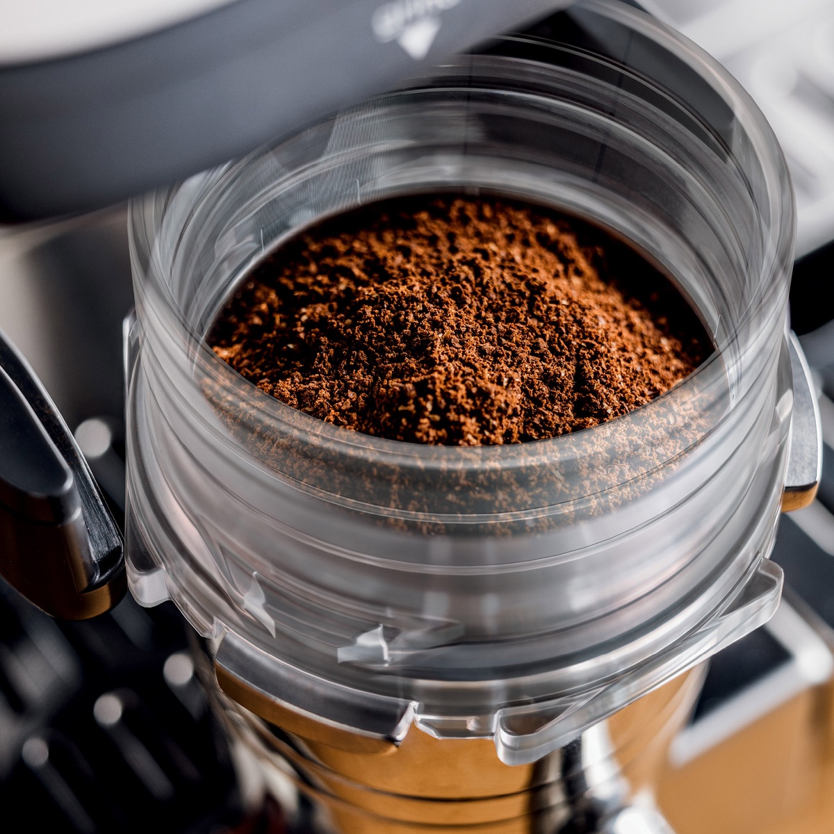 Close view of freshly ground coffee in the integrated grinder bin.