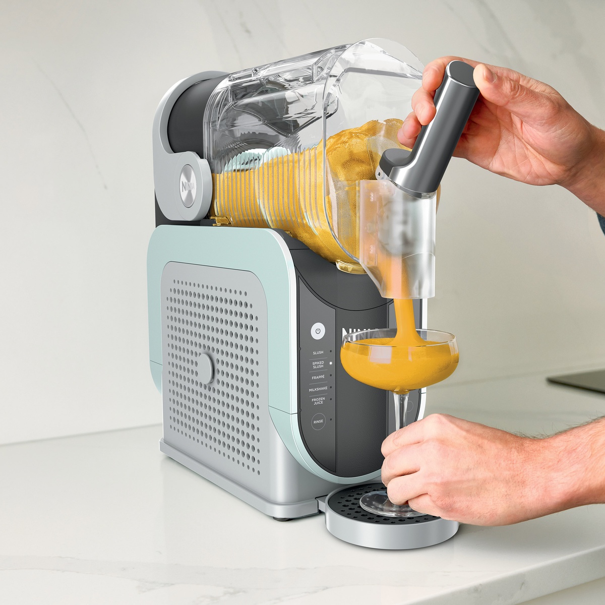 Dispensing smooth frozen drink from the spout into a cocktail glass on the drip tray.