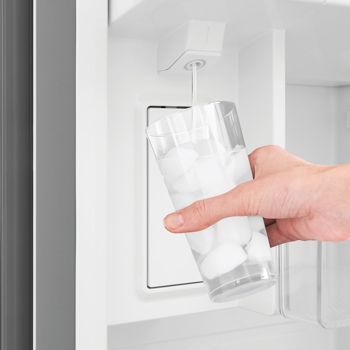Hand filling a glass from the internal water dispenser inside the refrigerator door