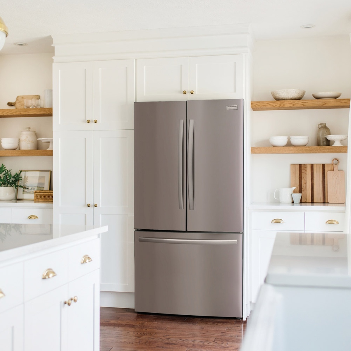 Lifestyle kitchen view with the refrigerator installed flush among white cabinetry