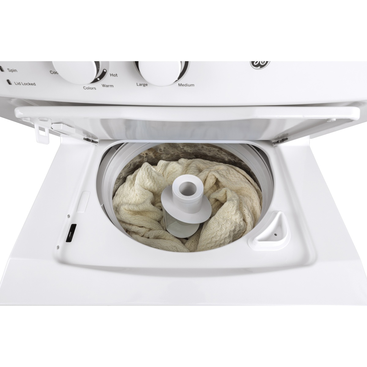 Washer tub in action with laundry and water around the central agitator.