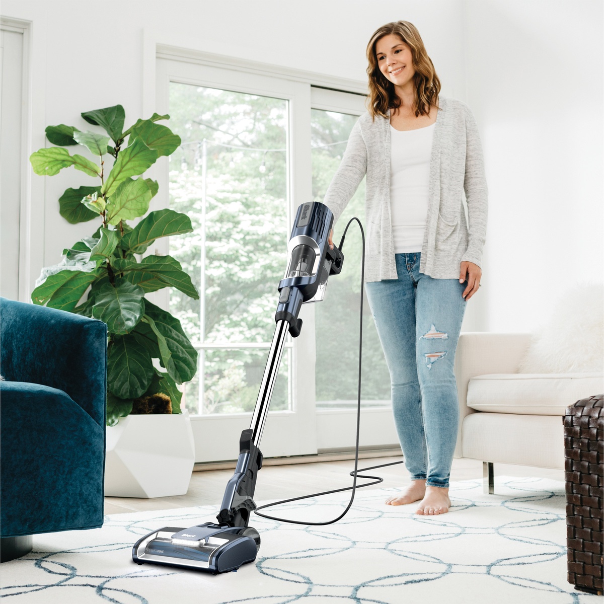 Person vacuuming a rug with the Shark UltraLight corded stick vacuum.