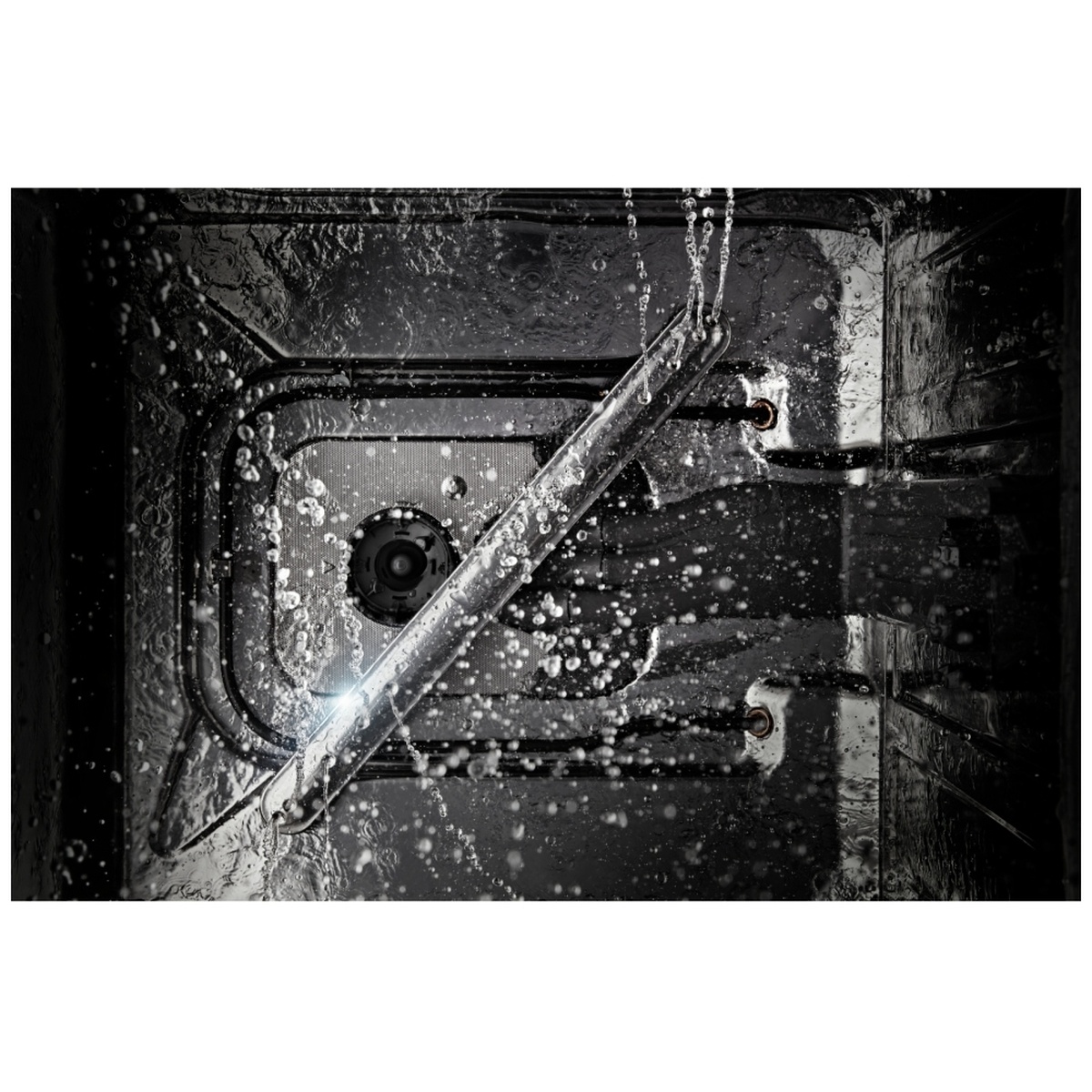 Inside dishwasher showing water spraying from stainless steel wash arm