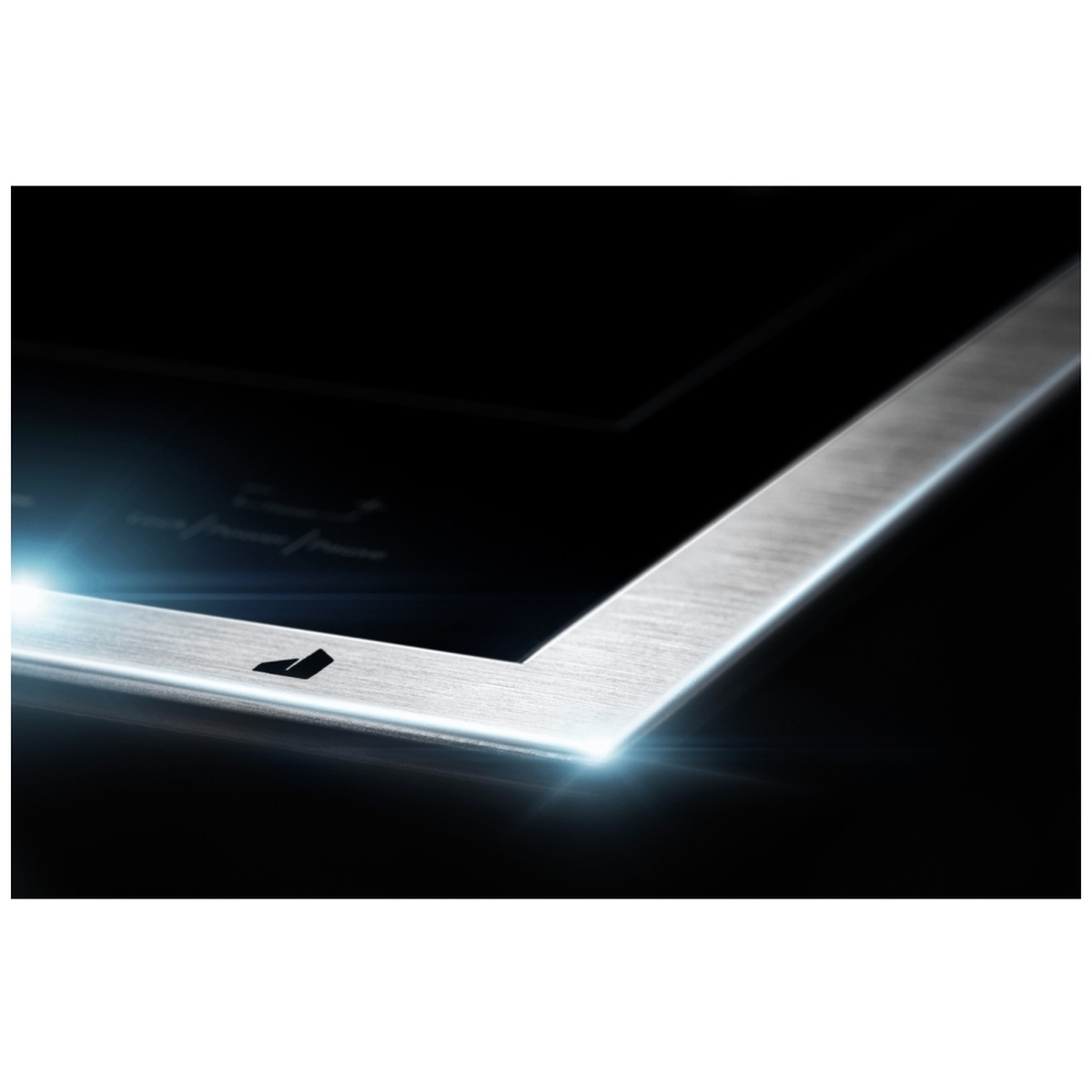 Corner detail of the cooktop showing the Lustre Stainless frame and refined edge