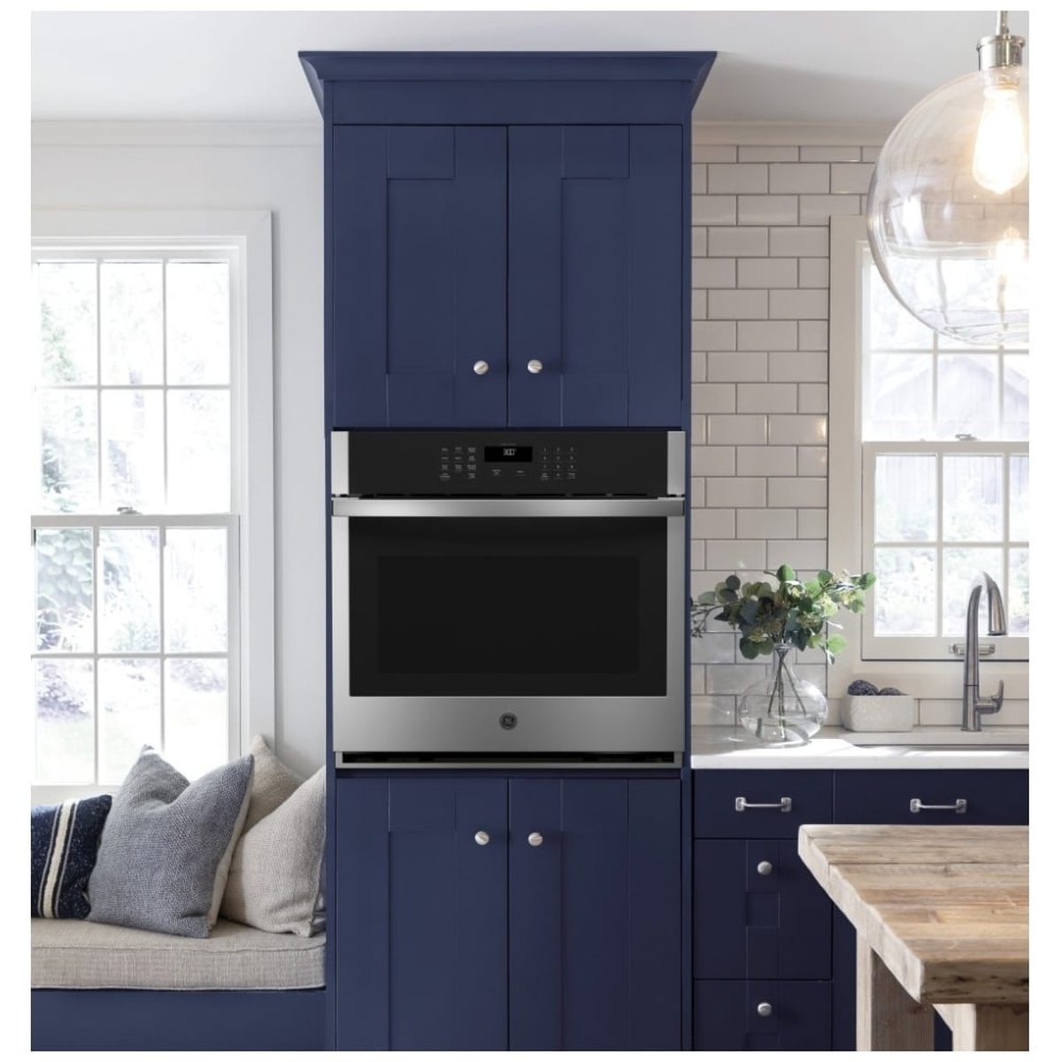 Wall oven installed in a modern kitchen cabinet, stainless front with large window.