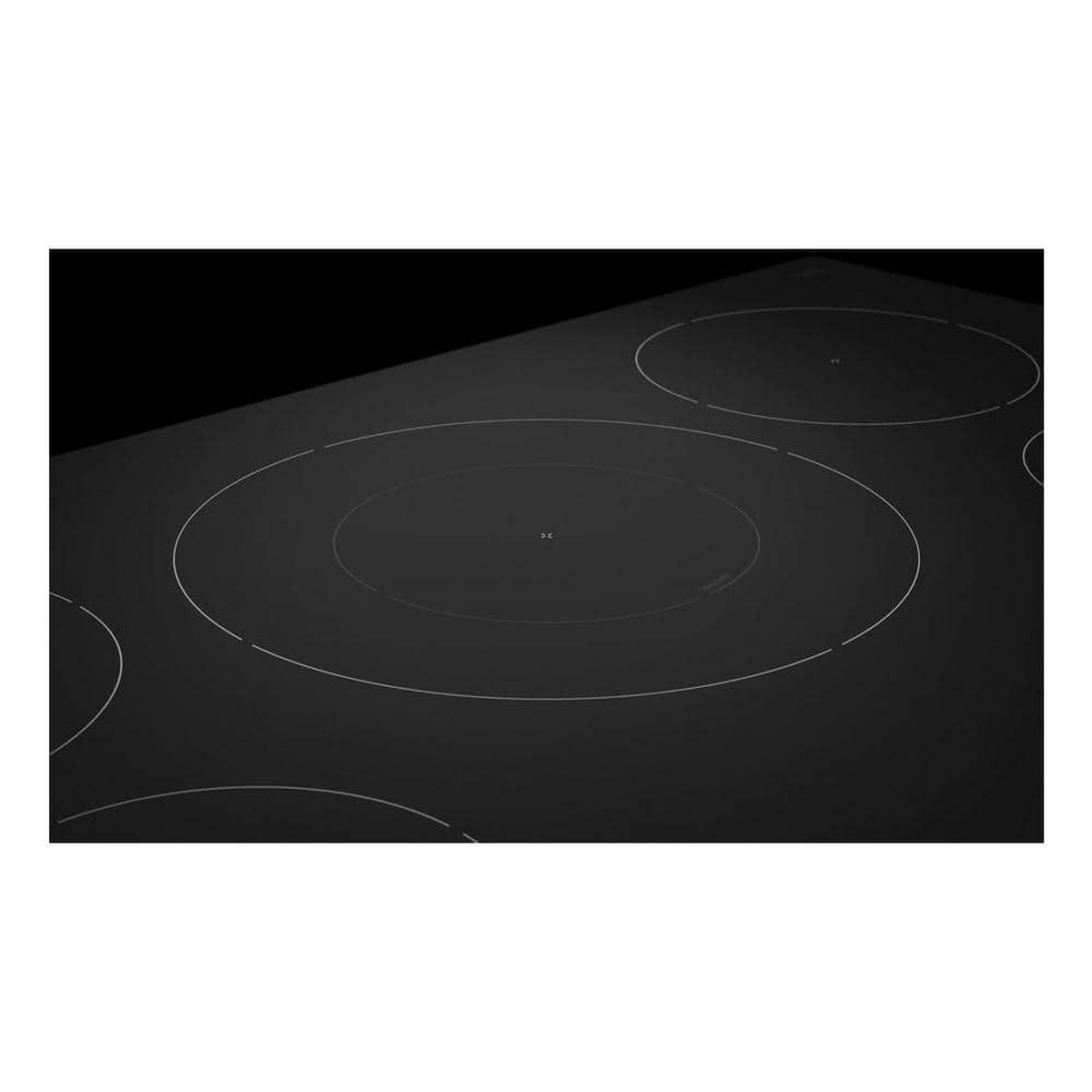 Close-up of the cooktop surface showing outlined induction elements on smooth black glass.