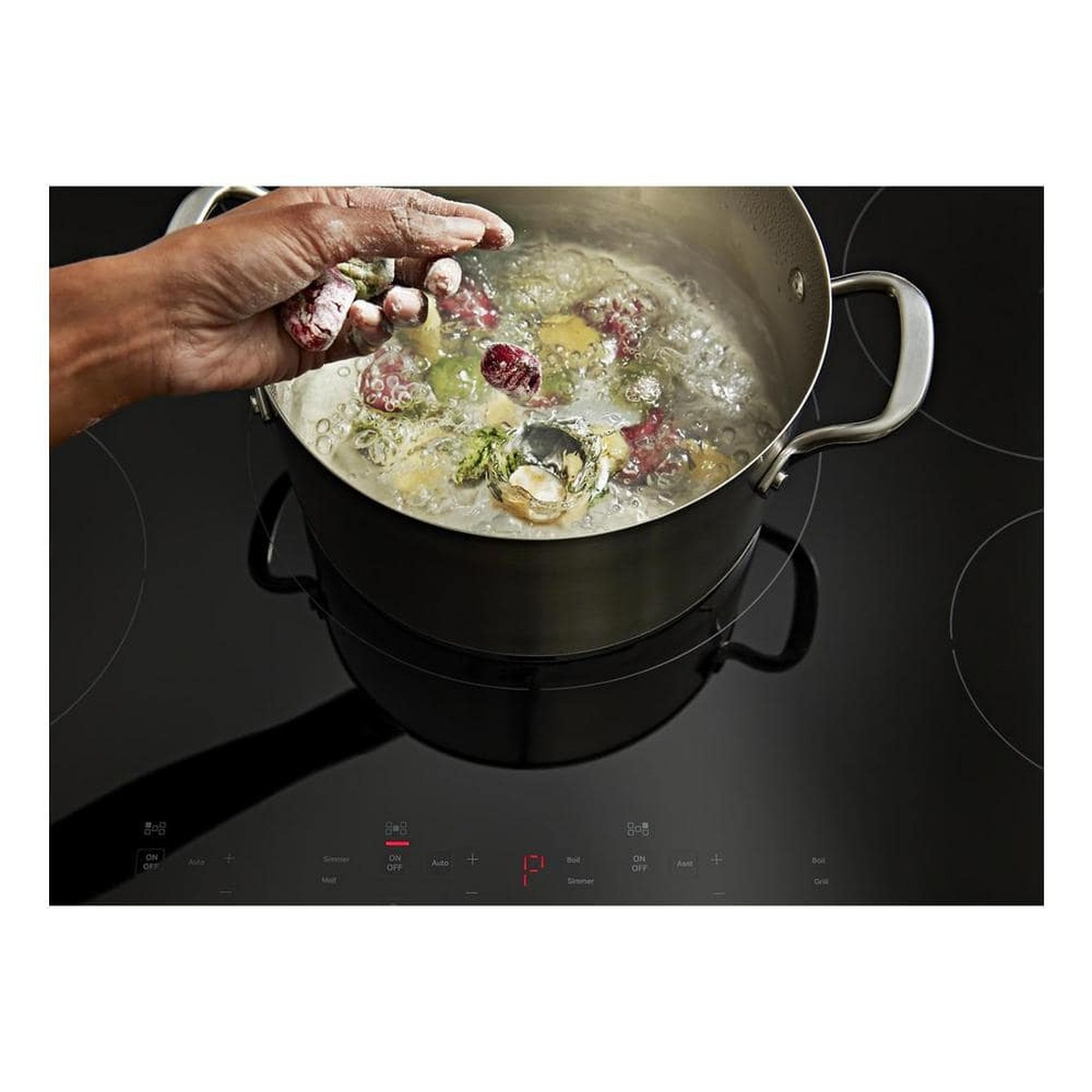 Boiling stockpot on the cooktop with touch controls showing Auto and Power Boost options.