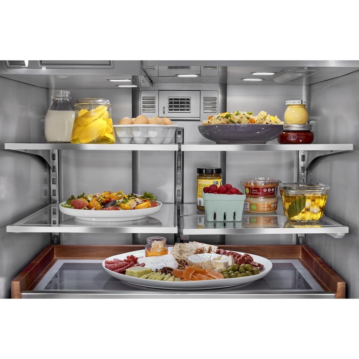 Interior shelves with full‑width pull‑out tray and adjustable slide‑away shelf loaded with food