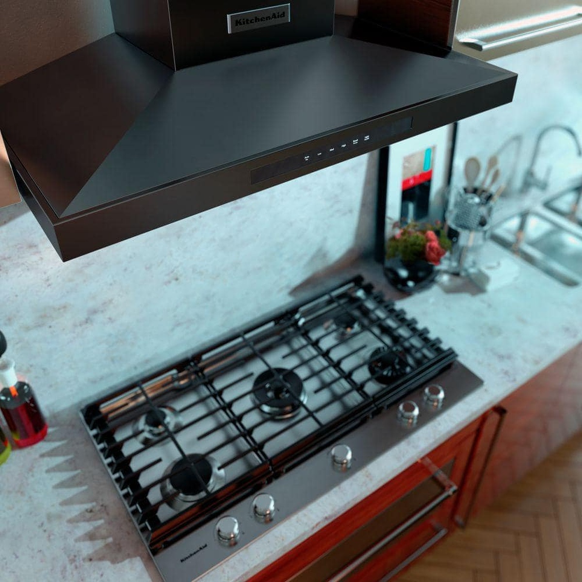 Range hood installed over gas cooktop with controls visible underneath.