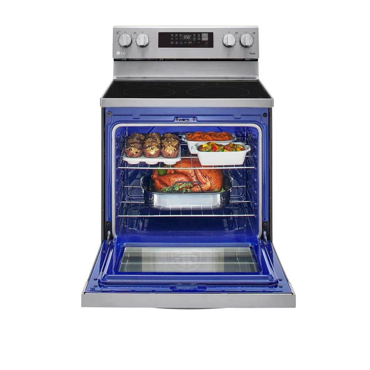 Open oven with blue interior loaded with multiple dishes on two racks