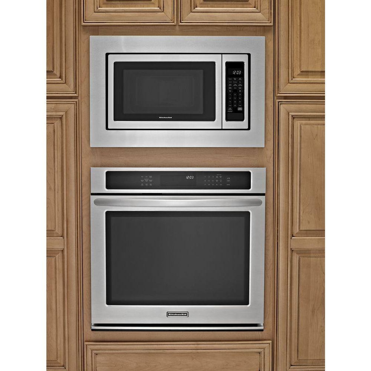 Microwave with trim kit installed above a wall oven inside cabinetry