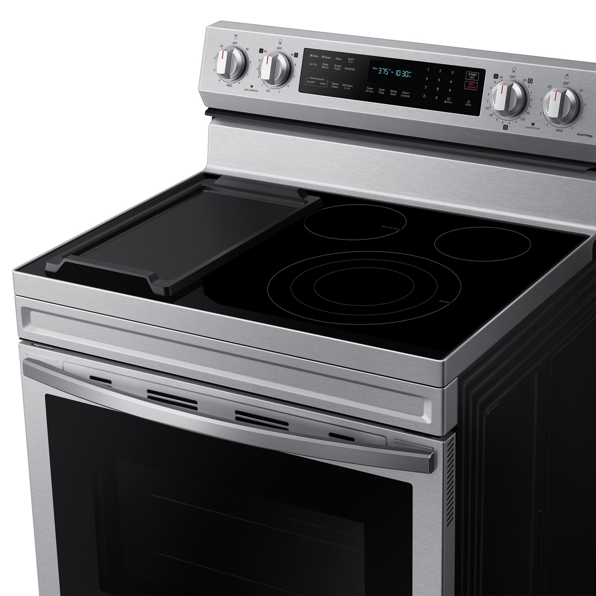 Glass cooktop with included griddle resting over left elements and knob controls.