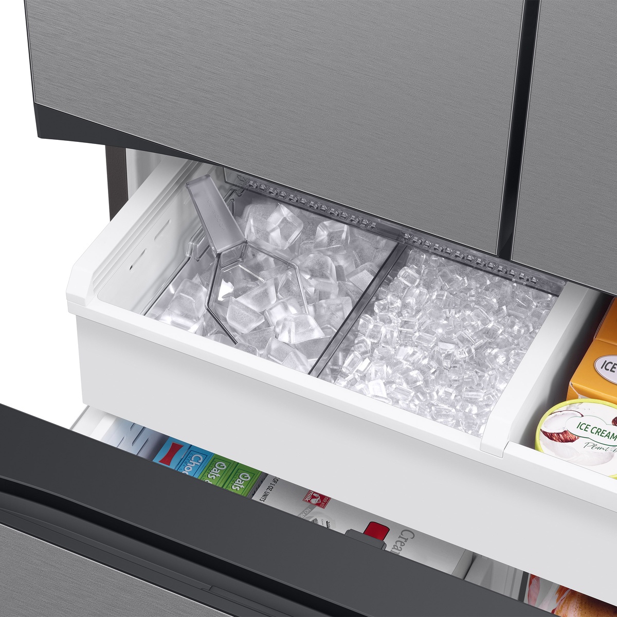 Freezer drawer with two types of ice in separate bins and an ice scoop.