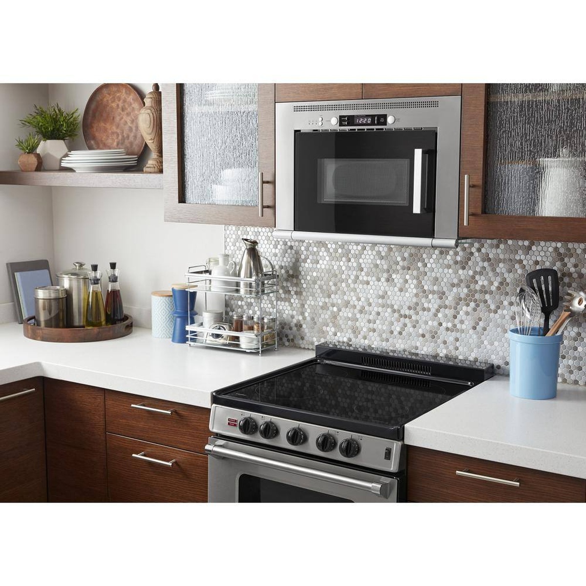 Compact over-the-range Whirlpool microwave installed above a 24-inch range in a small kitchen.