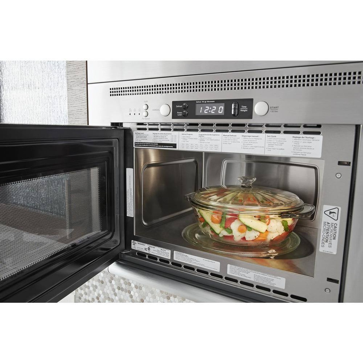 Stainless steel interior with glass turntable heating vegetables in a dish.