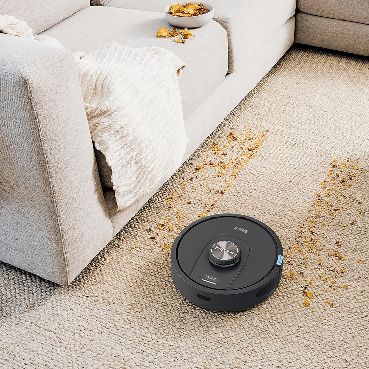 Robot vacuum cleaning visible crumbs along a carpeted path