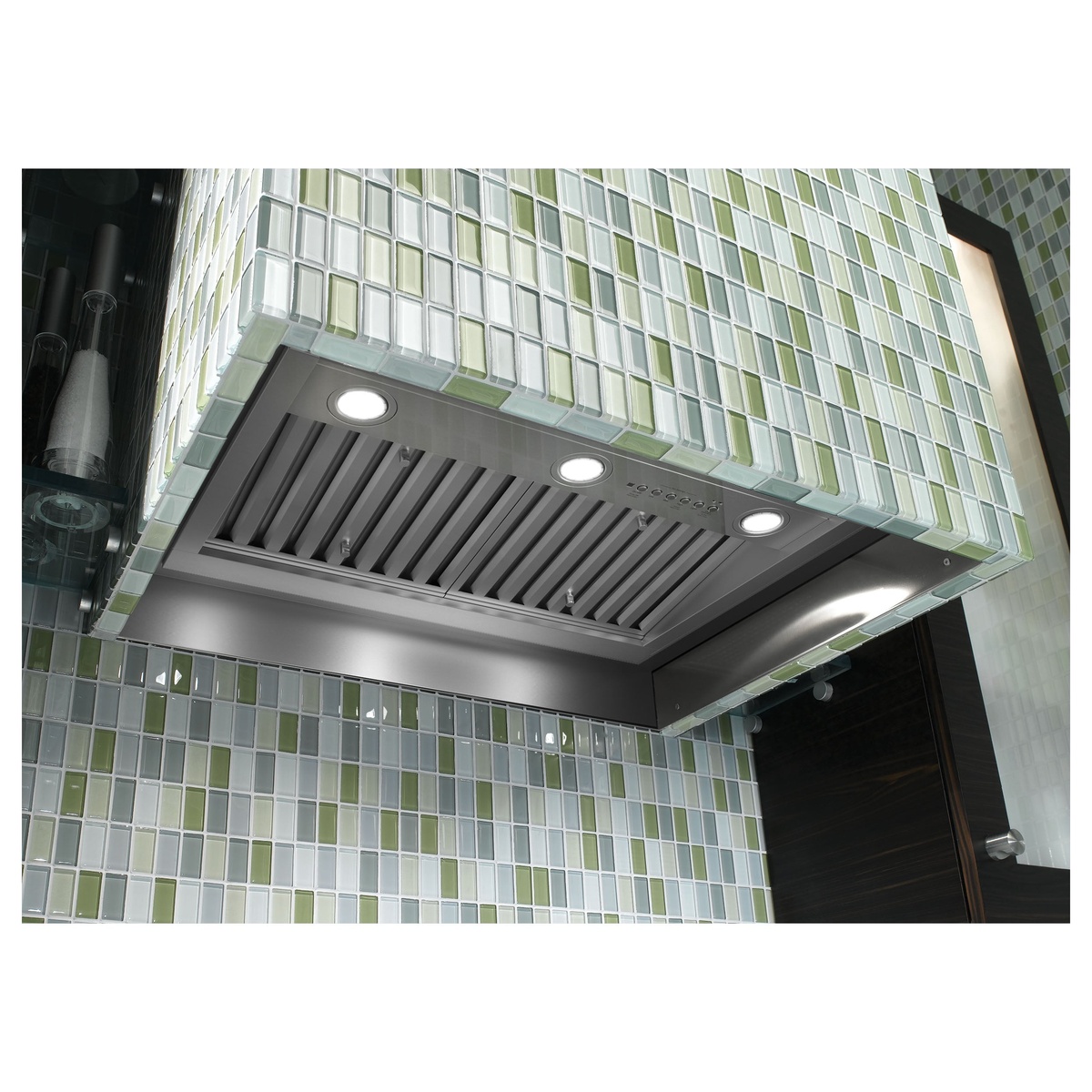 Installed GE insert range hood showing triple LED lights and baffle filters under custom cabinetry.