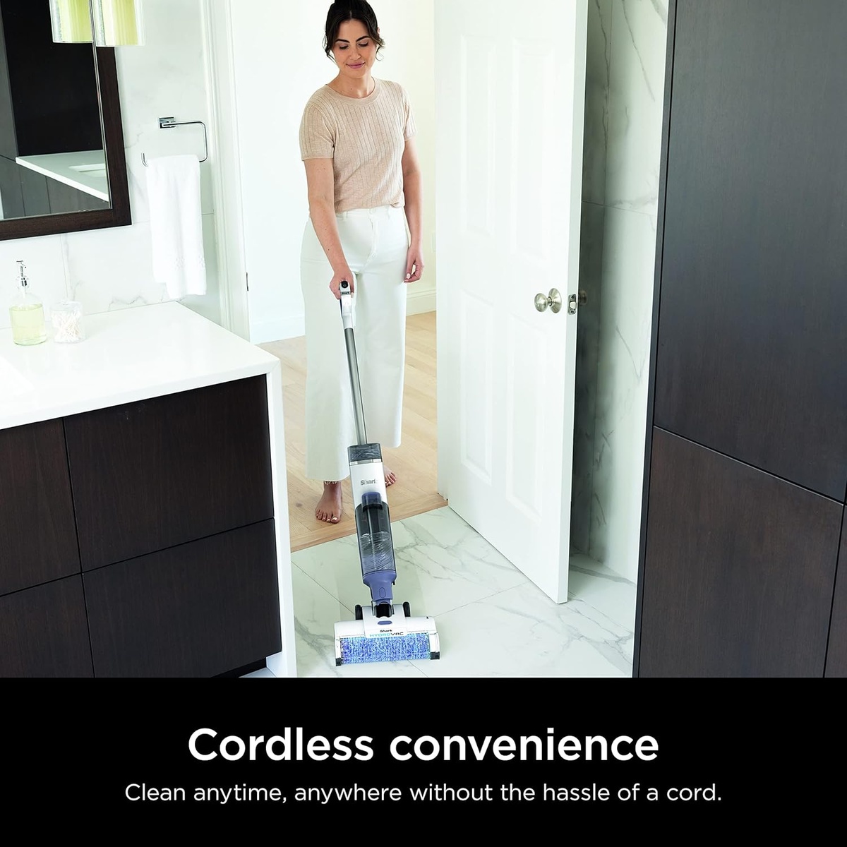 Person cleaning a bathroom floor with the cordless Shark HydroVac